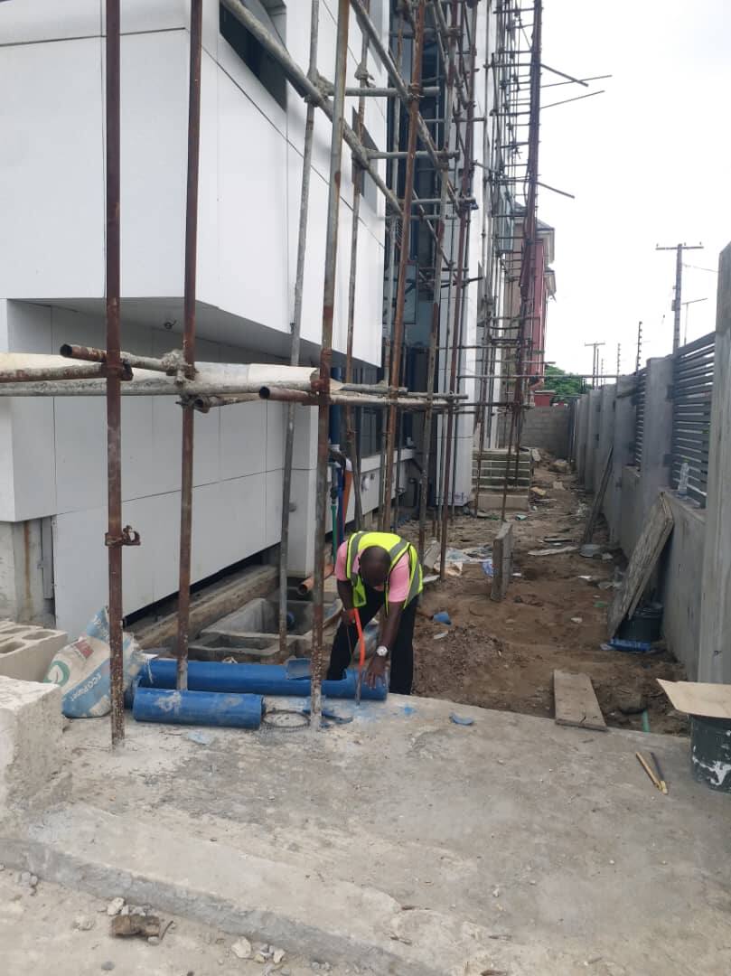 Plumber laying pipework on a building